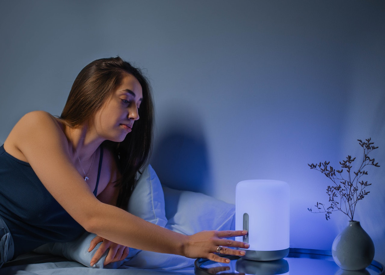 Woman is setting her night lamp to play her natural sounds