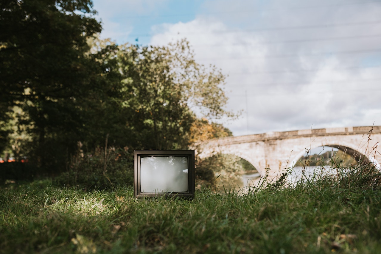 Old outdoor TV is standing on the grass